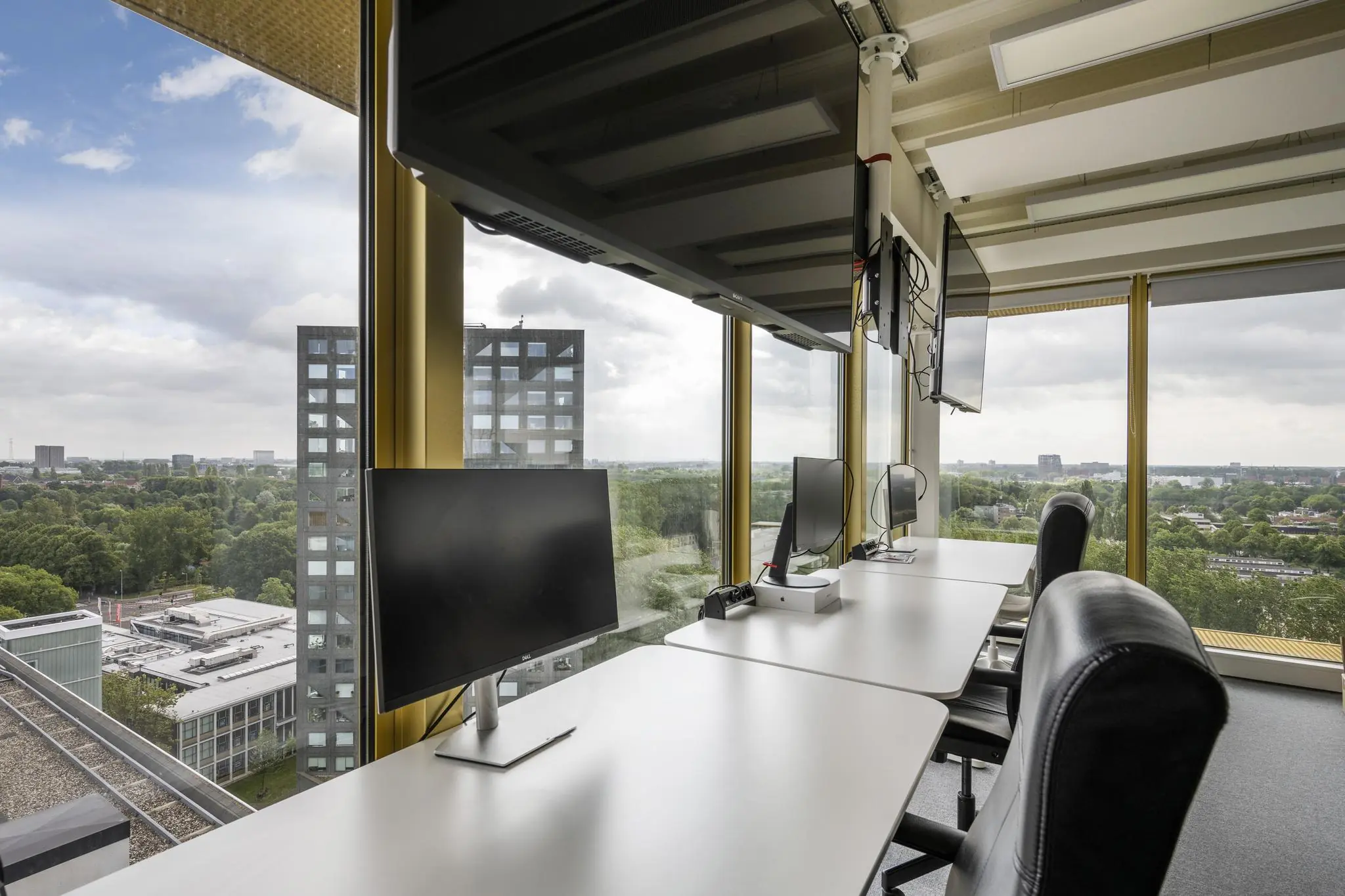 Moderne kantoorruimte aan de James Wattstraat met werkplekken en uitzicht op een groene stadsomgeving.